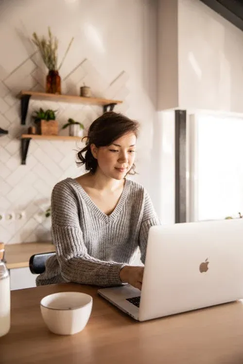 A woman sat at a desk, working on a laptop